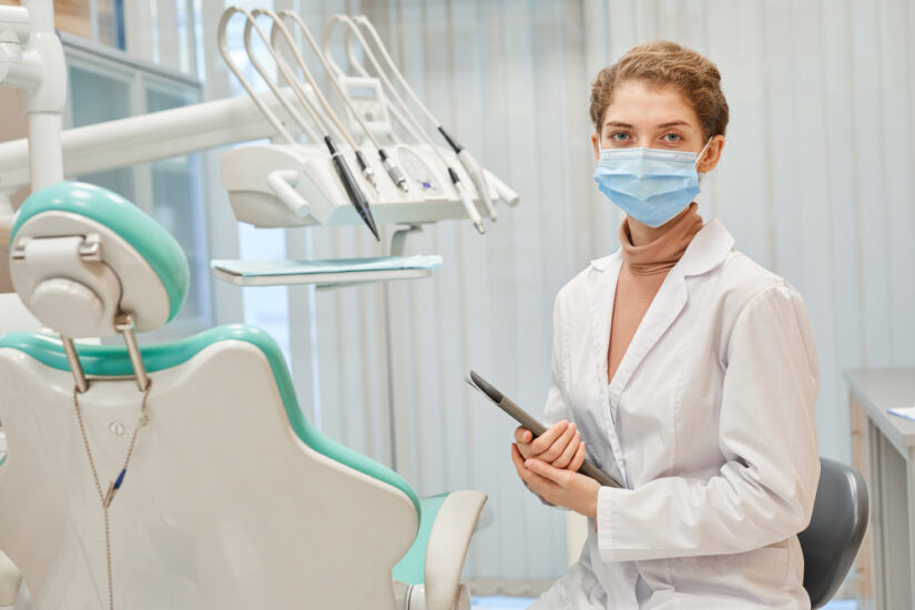 Photo of a Dentist in Mask and Lab Coat